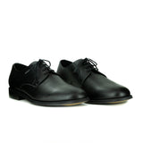 A simple black vegan leather men's dress shoe. Lace up with 4 eyelets, rounded wider toe box. Black sole.