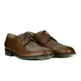 A simple tan vegan leather men's dress shoe. Lace up with 4 eyelets, rounded wider toe box. Dark brown sole.