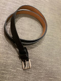 A 0.8 inch wide dress belt in black vegan leather. Nickel free silver buckle, tan/beige lining.